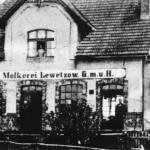 Mleczarnia, znajdowa&lstrok;a si&eogon; na wschodnim kra&nacute;cu wsi. Istnia&lstrok;a od 1907 do 1938. W g&oacute;rnym oknie Hedwig Duske (z d. Jeske). W lewych drzwiach stoi Ernst Duske, a w prawych drzwiach jego praktykant, Henschel, 1926